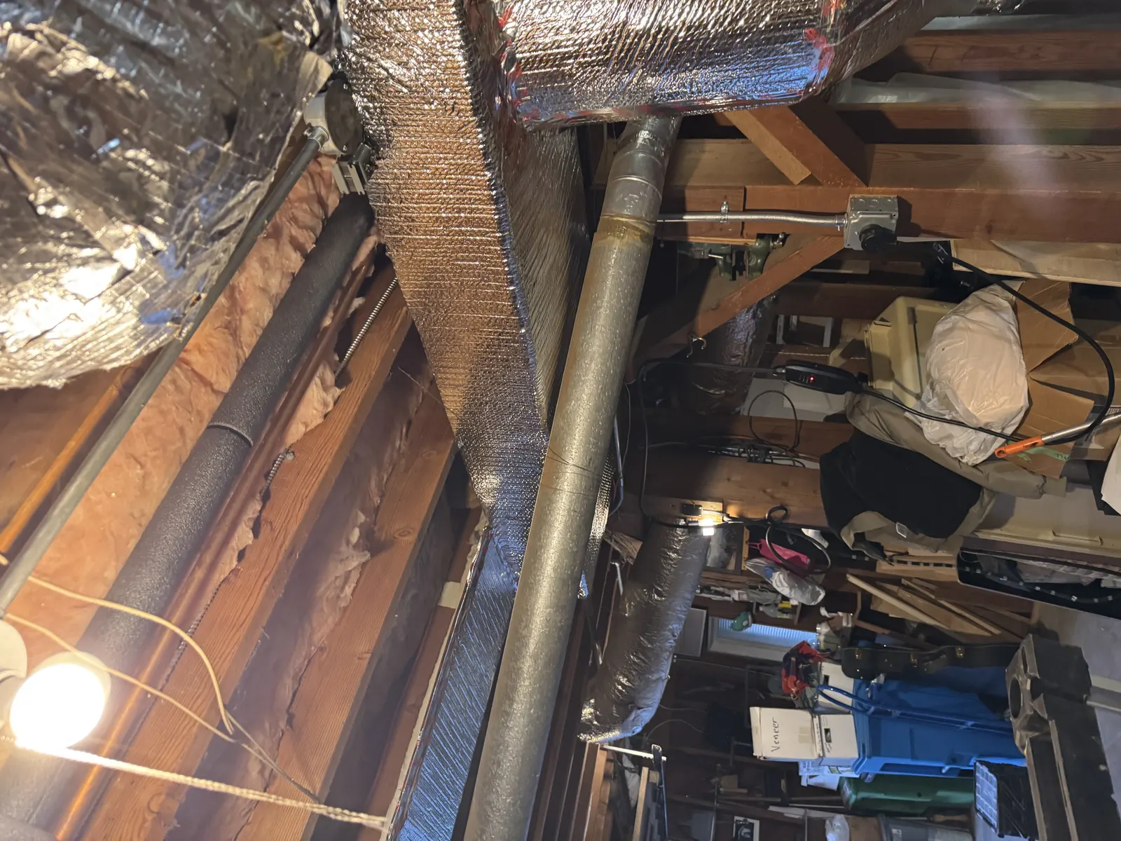 Insulated rigid sheet metal duct and round flex run between joists in a West Los Angeles attic during ductwork replacement